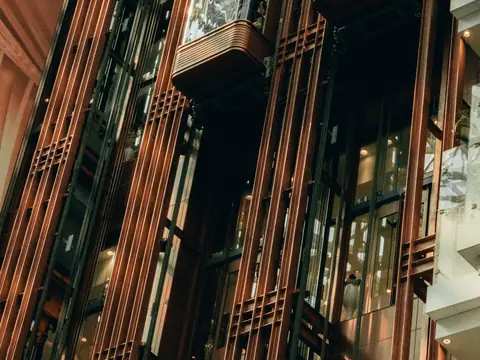Elevadores panorâmicos dentro de uma estrutura metálica com vidro
