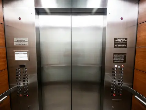 Porta de elevador em aço inox com botoeiras dos dois lados