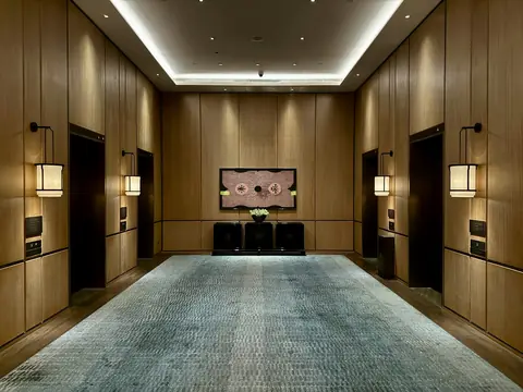 Hall de elevadores com paredes de madeira e iluminação suave
